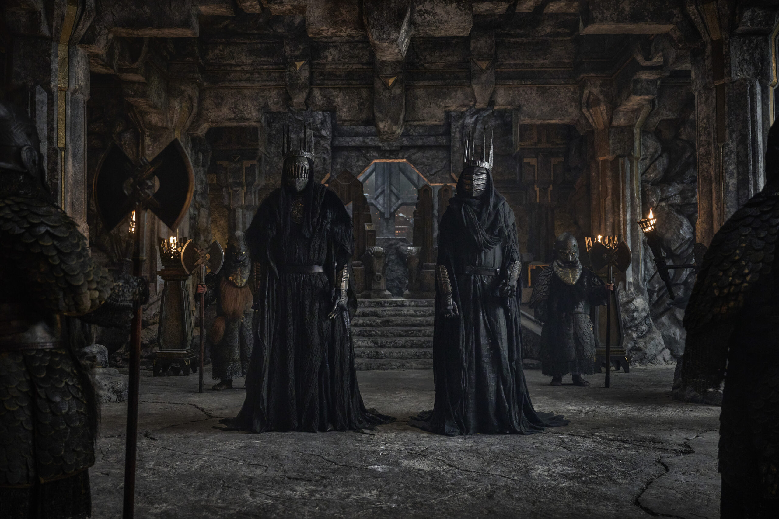 Two Ringwraiths in dark armor standing in Sauron's throne room in a behind-the-scenes still from The Lord of the Rings: The Rings of Power Season 3