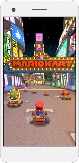 Mario and other racers driving under a neon Mario Kart arch in Mario Kart Tour