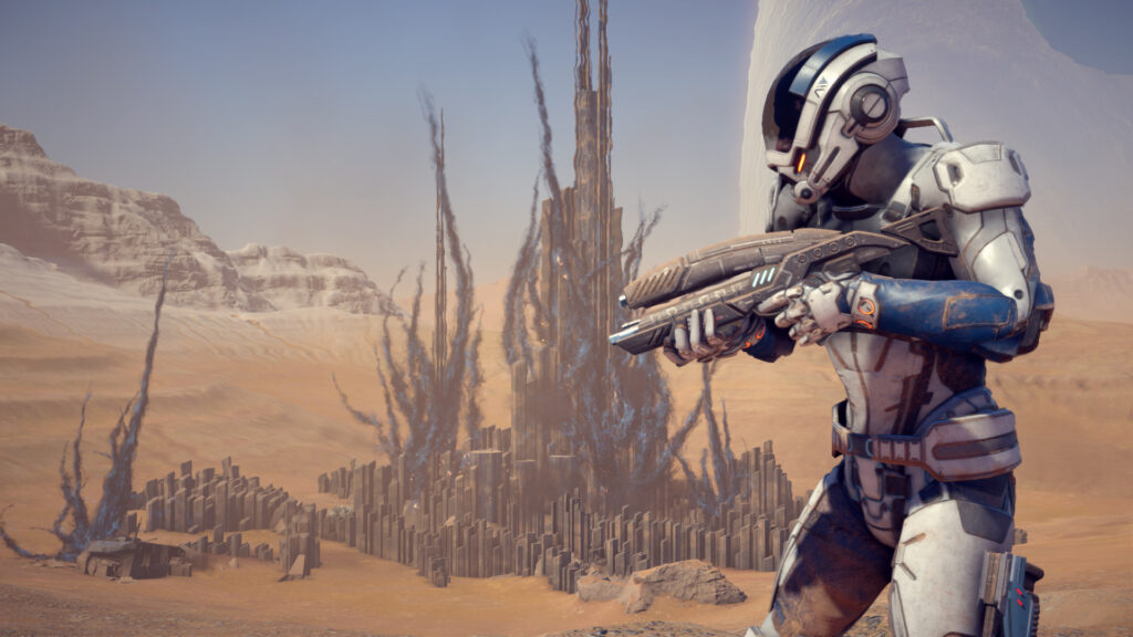 An armored explorer with a rifle on a desert world in Mass Effect Andromeda